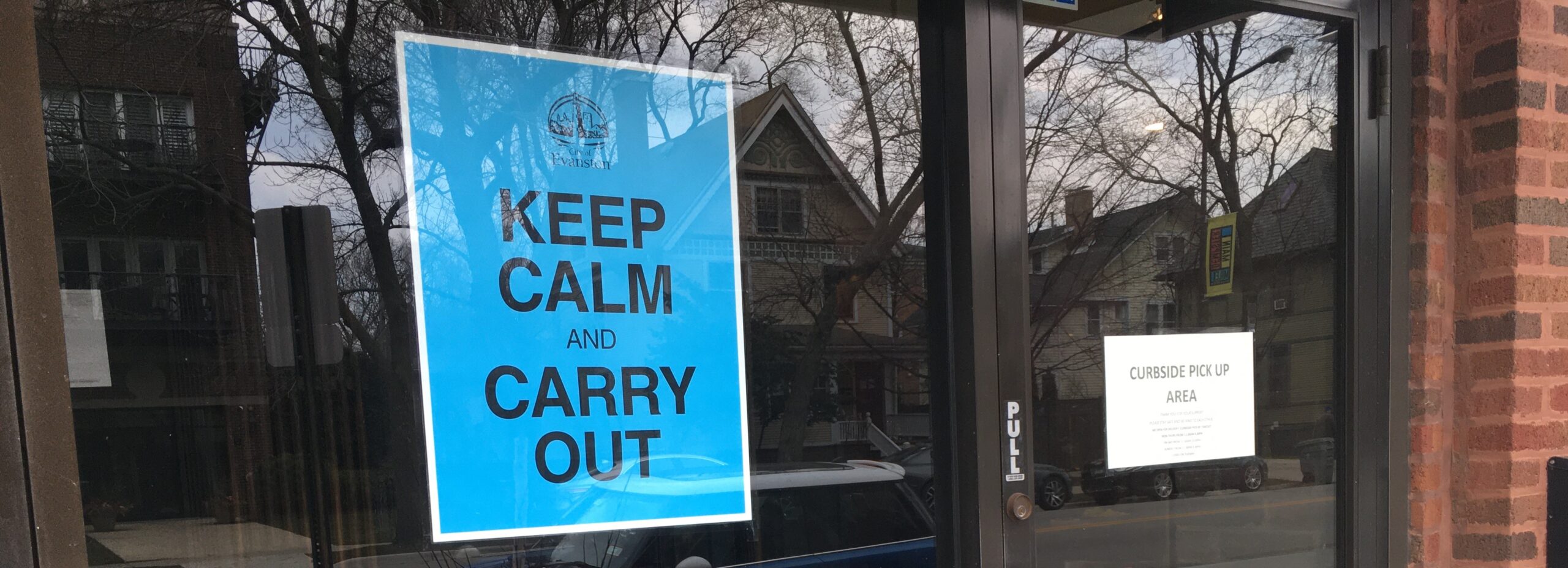 a shop front with a poster that says keep calm and carry out